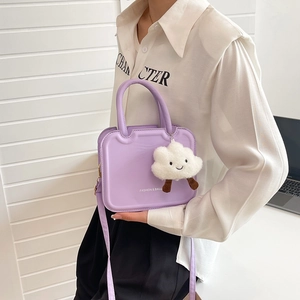 Minimalist purple matte crossbody cookie bag with white cloud plush pendant shown on model