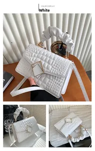 Détail du sac à main blanc motif crocodile avec poignée froncée et fermoir métal