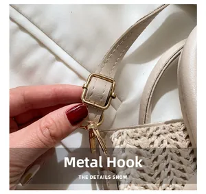 Close-up of golden metal hooks and beige woven texture on a stylish small crossbody bag