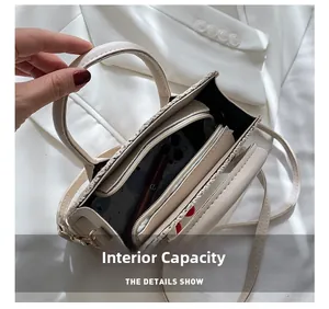 Internal capacity of cream woven shoulder bag showing a phone and zipper compartment