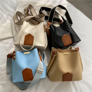 Sacs seaux bicolores en blanc, noir, bleu et kaki avec de larges bandoulières souples