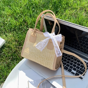 Sac bandoulière rétro en paille avec nœud en dentelle sur une table extérieure