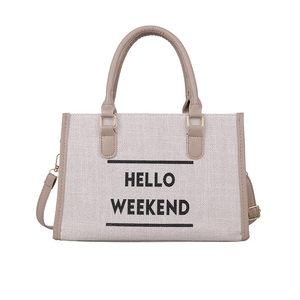 Off-white canvas tote bag with Hello Weekend text and brown leather shoulder straps