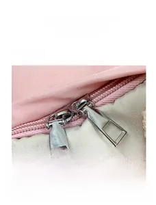 Dettaglio della borsa in nylon rosa e beige con doppia cerniera in metallo e trama fine