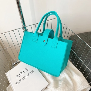 Minimalist green felt tote bag with metal snap button in a stylish wire mesh basket