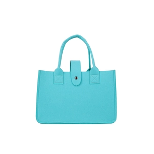 Large blue felt tote bag with round handles and metal button closure on white background