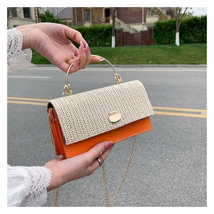 Detailed close-up of woven flap design with orange leather and golden ring handle