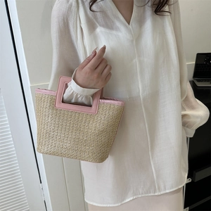 Detailed texture of handwoven straw tote bag with elegant pink square leather handles