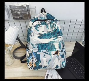 Close-up of street graffiti style backpack with UNRULY print on a wooden desk setup