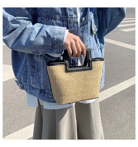 Detail of woven straw tote bag with black faux leather trim and square cut-out handle