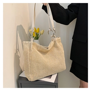 Detailed straw tote bag texture with white leather strap and silver ring hardware detail