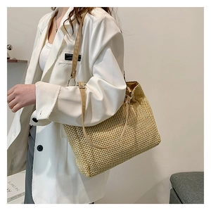 Large capacity beige straw tote bag with brown straps styled on a white blazer outfit