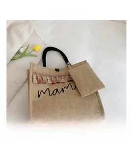 Flat lay of beige linen mama tote bag with colorful tassels and matching small coin purse