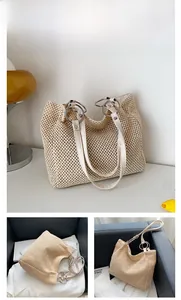 Detail of beige woven straw tote bag showing silver metal rings and leather handles