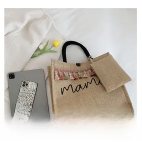 Detail of khaki woven mama tote bag featuring colorful tassels and matching mini pouch