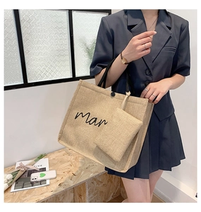 Detail of linen tote bag with 'man' embroidery and matching small accessory pouch