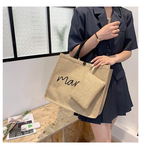 Detail of linen tote bag with black handle and mar text plus matching pouch
