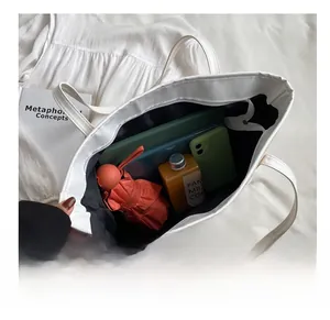Top view of white straw tote bag showing large capacity with daily essentials inside