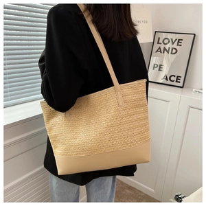 Detail of a large straw tote bag featuring woven texture and PU leather straps for summer
