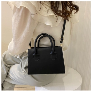 Vue détaillée d'un sac à main noir en similicuir sur un modèle pour la taille et le style