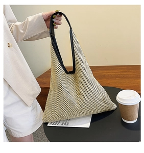 Detail of hand-woven beige summer tote bag with black leather trim and single handle