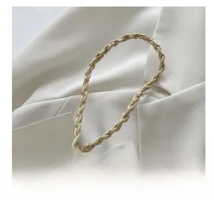 Detail showing the braided texture and spiral craftsmanship of the cream straw shoulder strap