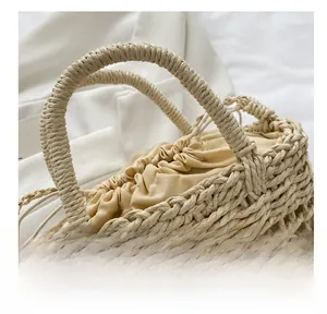 Detail of hand-woven beige beach bag handle with drawstring liner and texture