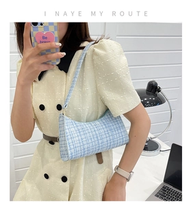 Détail du sac à bandoulière en tweed à carreaux bleu et blanc et sa texture en tissu