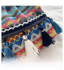 Gros plan d'un sac seau au crochet ethnique coloré avec motifs vagues et glands bleus