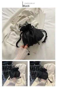 Detail of black drawstring bucket bag with sheer bow and white pearl beaded handle