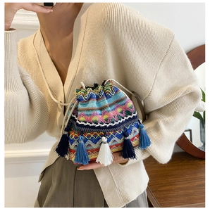 Gros plan détaillé du sac seau en tricot ethnique coloré avec de longues franges et motifs
