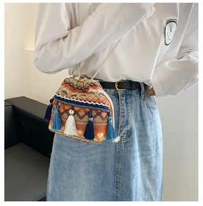 Détail d'un sac seau boho tissé avec motifs colorés et pampilles à franges pendantes