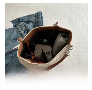 Detail view of large straw tote bag interior showing capacity with personal items