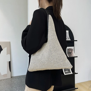 Minimalist beige woven shoulder bag with black leather strap for modern women