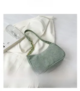 Detail of green corduroy shoulder bag with gold metal and acrylic link chain strap