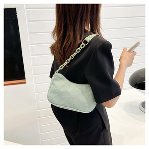 Mint green corduroy shoulder bag with chunky chain strap shown on a model