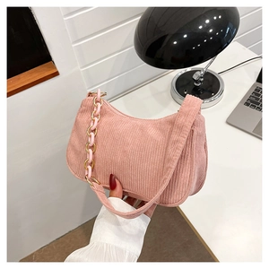 Detail of pink corduroy shoulder bag showing the unique chunky resin and metal chain strap