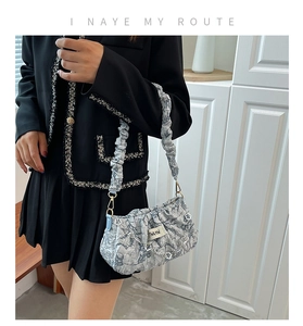 Detail of grey pleated cloud bag showing wrinkled texture and silver flower chain strap