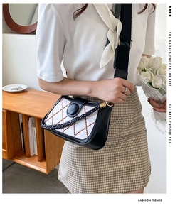 Close-up of quilted chain crossbody bag with pearl weave strap and black leather details