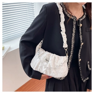 Detail of white pleated cloud bag with metallic chain and textured fabric finish