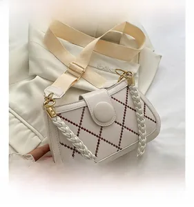 Macro shot of white crossbody bag with reddish-brown stitching and gold buckle detail
