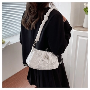 Close-up of white ruched cloud bag featuring a delicate silver floral metal chain