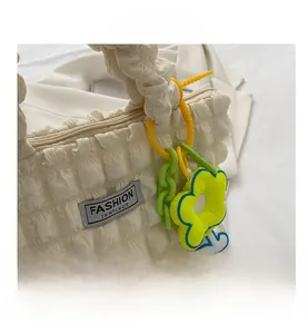 Detailed macro view of puffy bubble textured fabric handbag with green flower charm