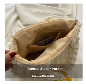 Detailed interior of a white bubble textured bag showing beige lining and zipper pocket
