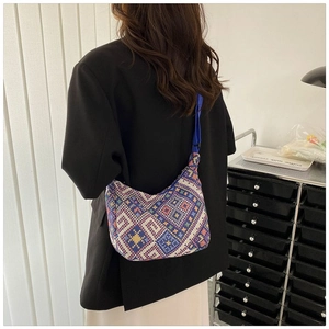 Detail of bohemian geometric woven crossbody bag with colorful patterns and adjustable strap