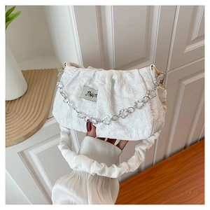 Detail of white pleated cloud bag showing 3D texture and silver petal chain strap