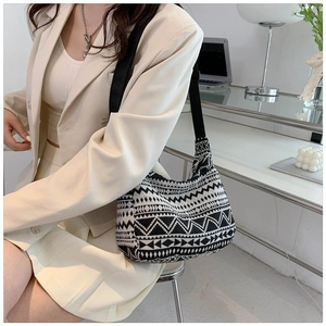 Detail of a half-moon shoulder bag with black and white geometric ethnic patterns