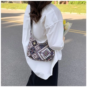 Detailed view of women's crossbody bag featuring ethnic geometric woven patterns