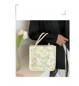 Detailed view of beige floral canvas tote bag with white braided rope handles for women