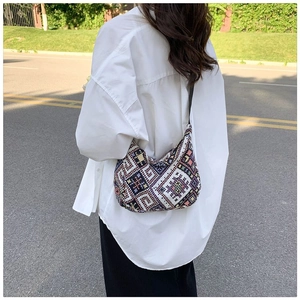Detail of bohemian geometric woven hobo bag with colorful jacquard pattern and slim strap